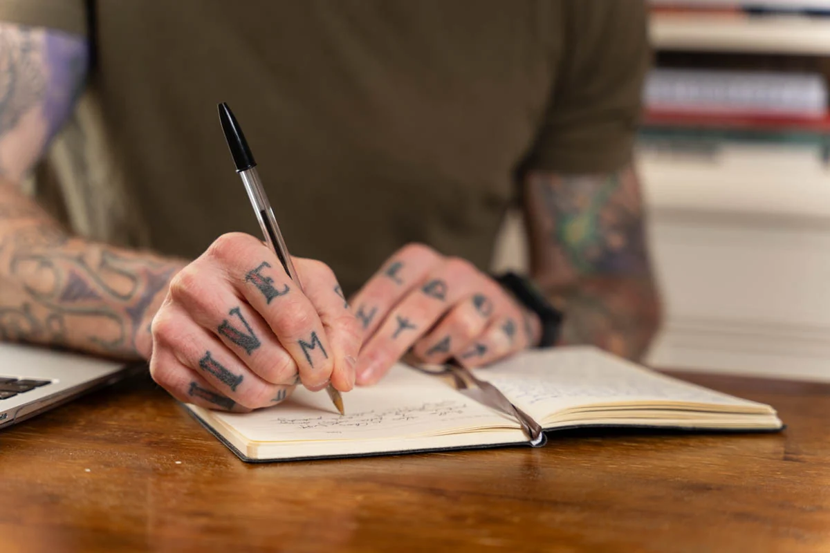 Chris writing notes in a notebook during messaging work